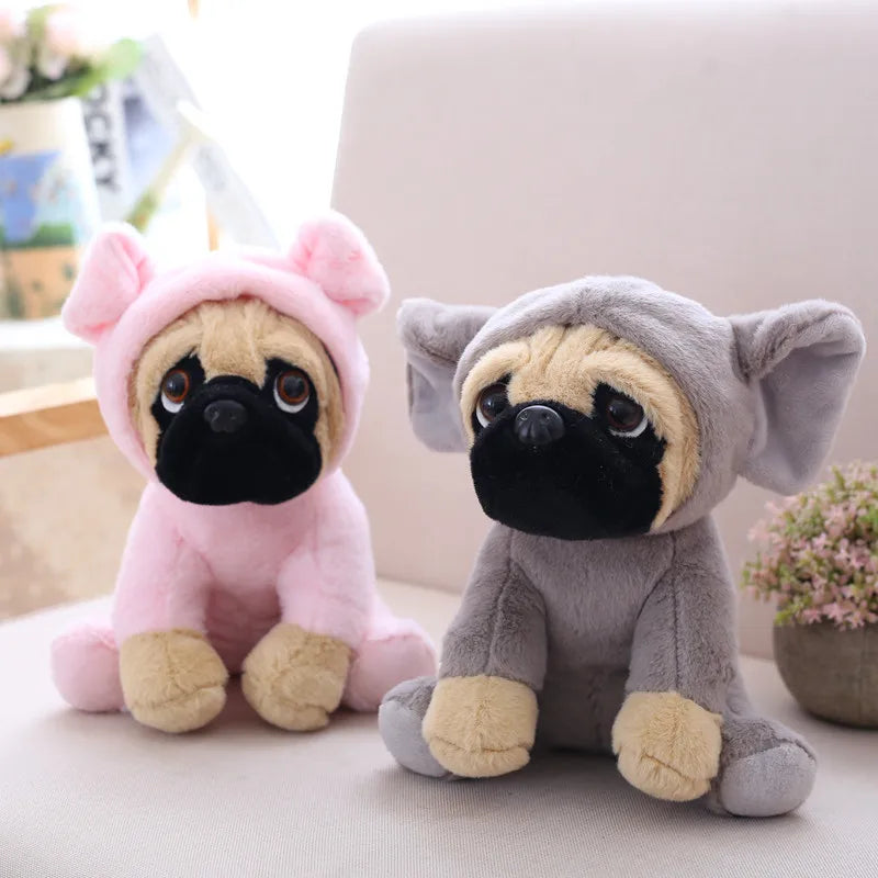 Two plush toys, one pink and one gray, shaped like pugs on a light-colored surface.