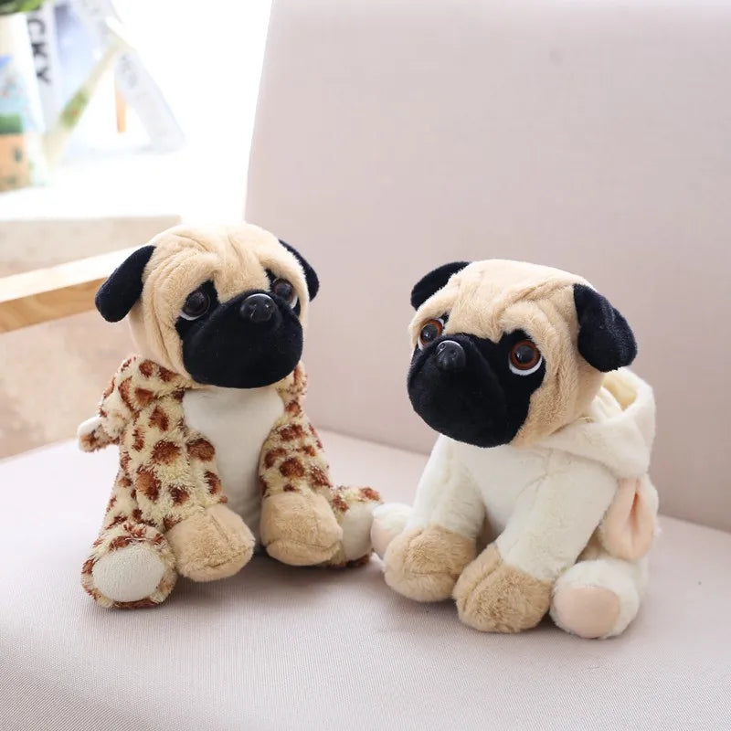 Two plush pug dogs with scarves on a light-colored surface.