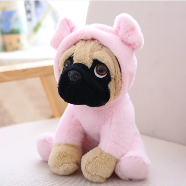 Plush toy pug dog in a pink outfit on a light-colored surface.