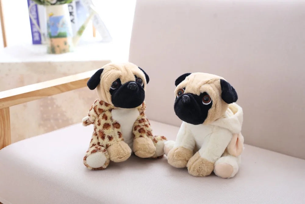 Two plush pug toys sitting on a light-colored surface with a blurred background.