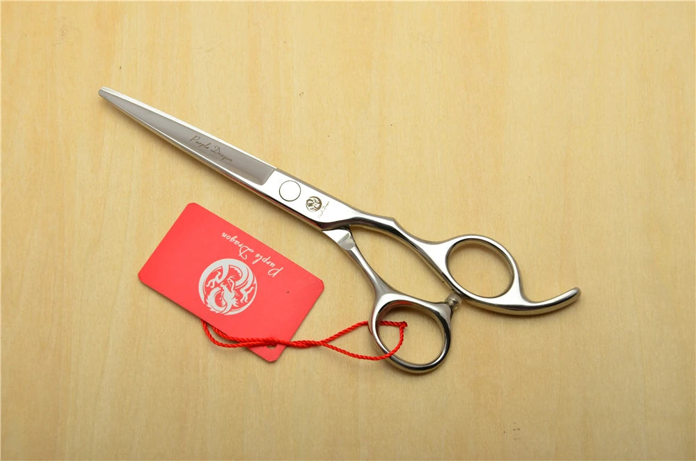 Silver scissors with a red tag on a wooden surface