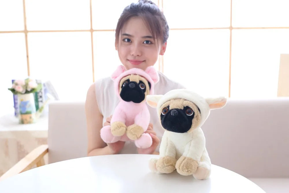 Person holding two plush dog toys on a table with a light-colored wall in the background