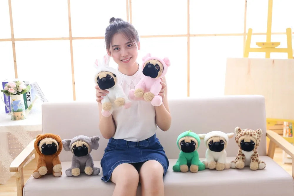 Woman holding plush pug toys on a couch with a light-colored wall in the background