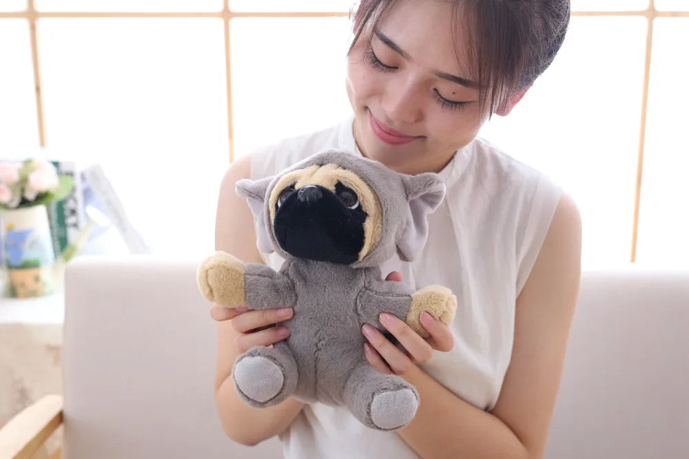Woman holding a plush pug toy on a light-colored couch.