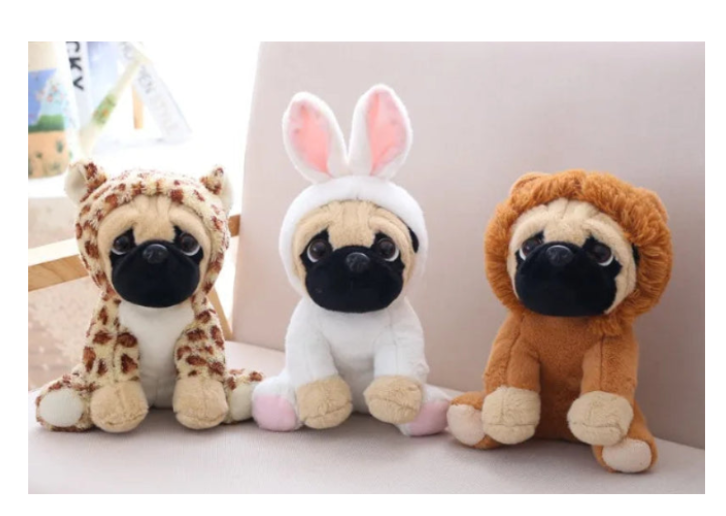 Three plush toys shaped like pugs in different animal costumes on a white couch.