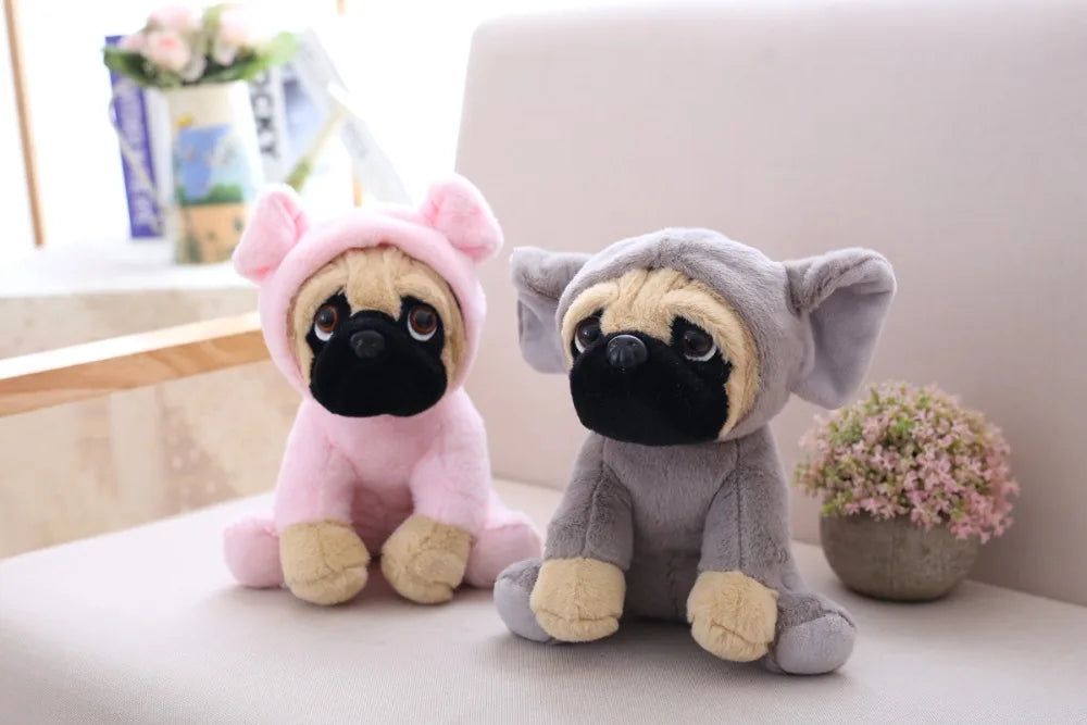 Two plush toys, one pink and one gray, resembling pugs in animal costumes on a light surface.