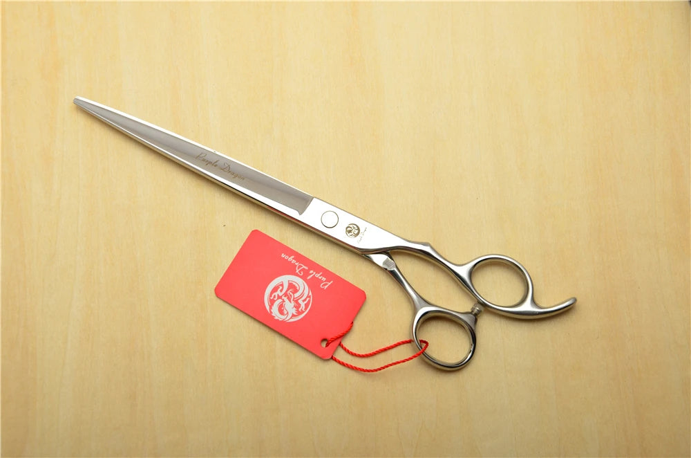 Silver scissors with a red tag on a wooden surface