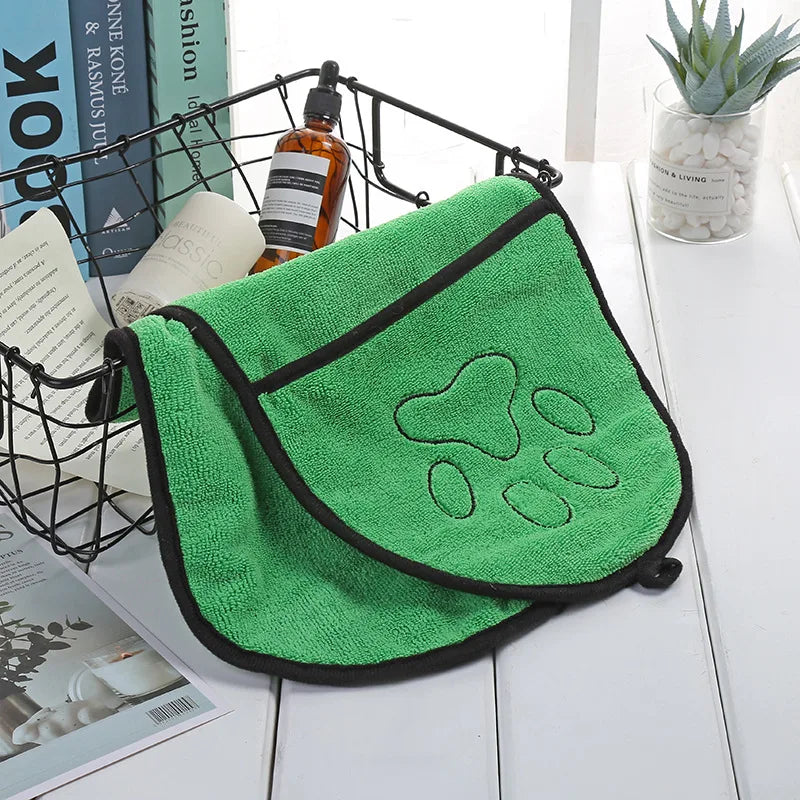 Green towel with paw print design on a white surface