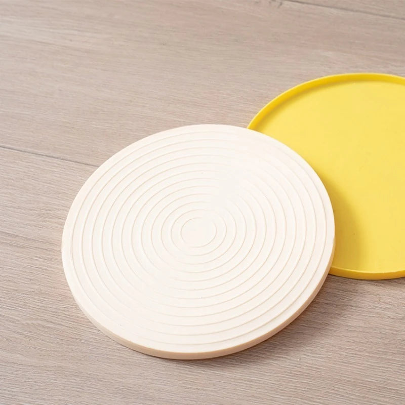 Round white and yellow coasters on a wooden surface