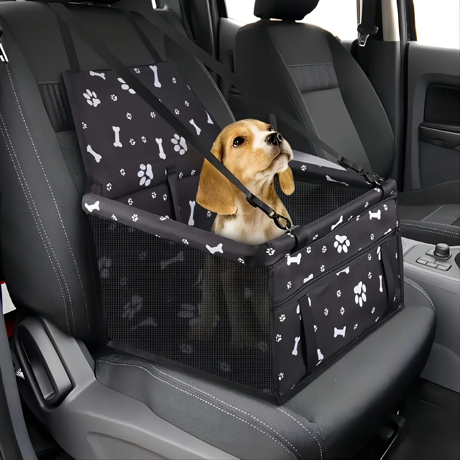 Dog in a pet seat harness inside a car with a black and white patterned cover.