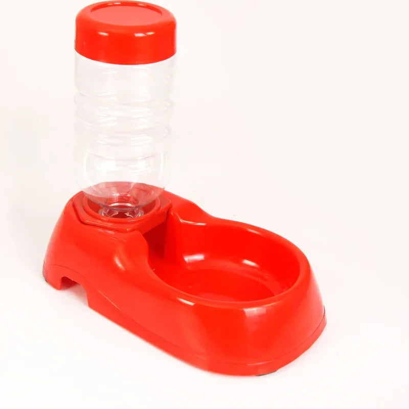 Red and clear plastic pet feeder on a white background