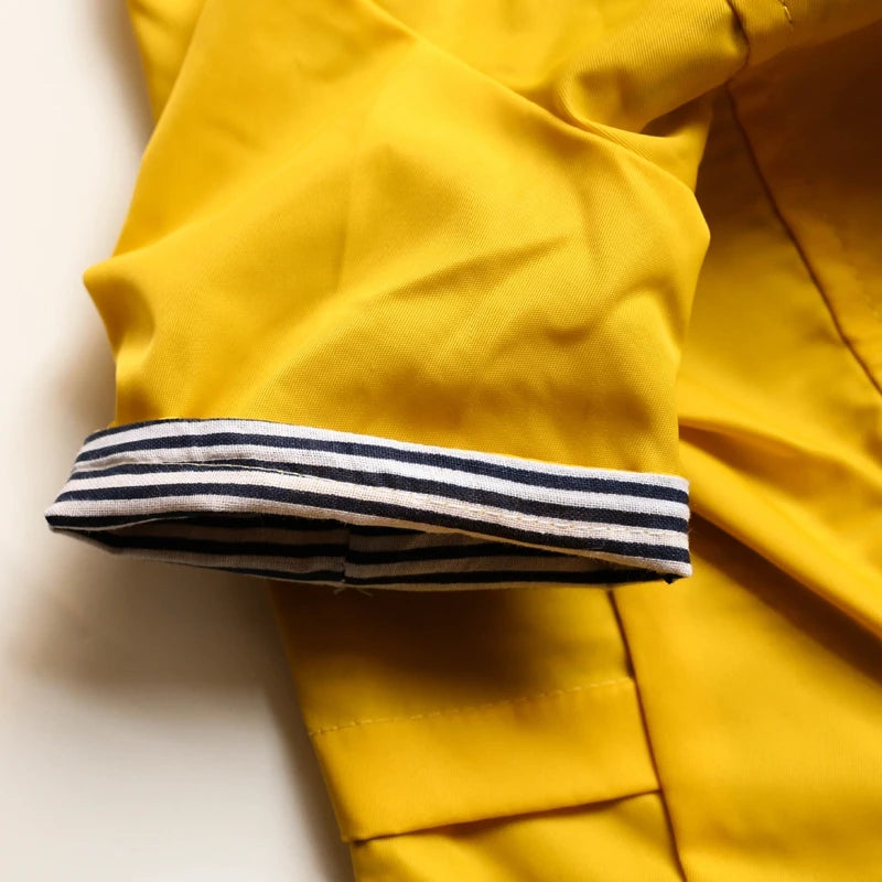 Close-up of a yellow jacket with striped cuffs on a light background
