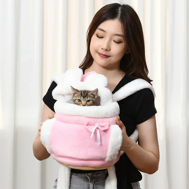 Woman holding a pink pet carrier with a cat inside against a white curtain background