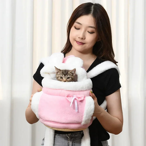 Woman holding a pink pet carrier with a cat inside against a white curtain background