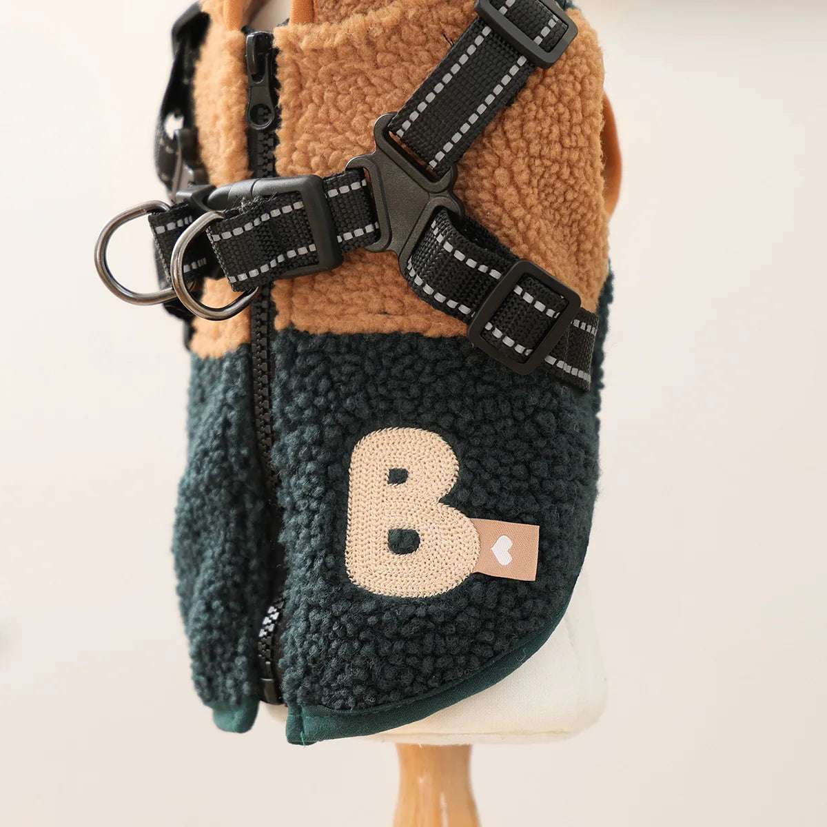 Dog harness with a letter 'B' patch on a mannequin against a white background