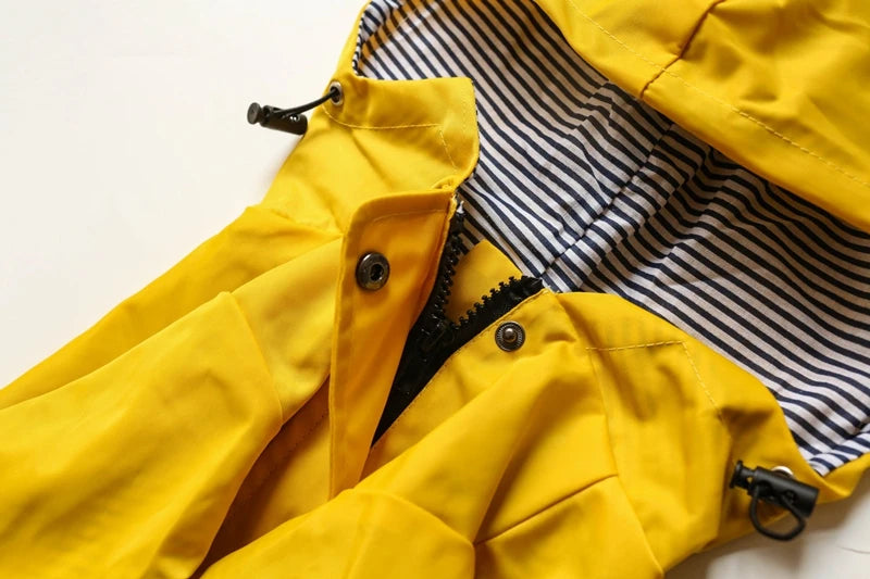 Close-up of a yellow raincoat with a striped lining on a light background