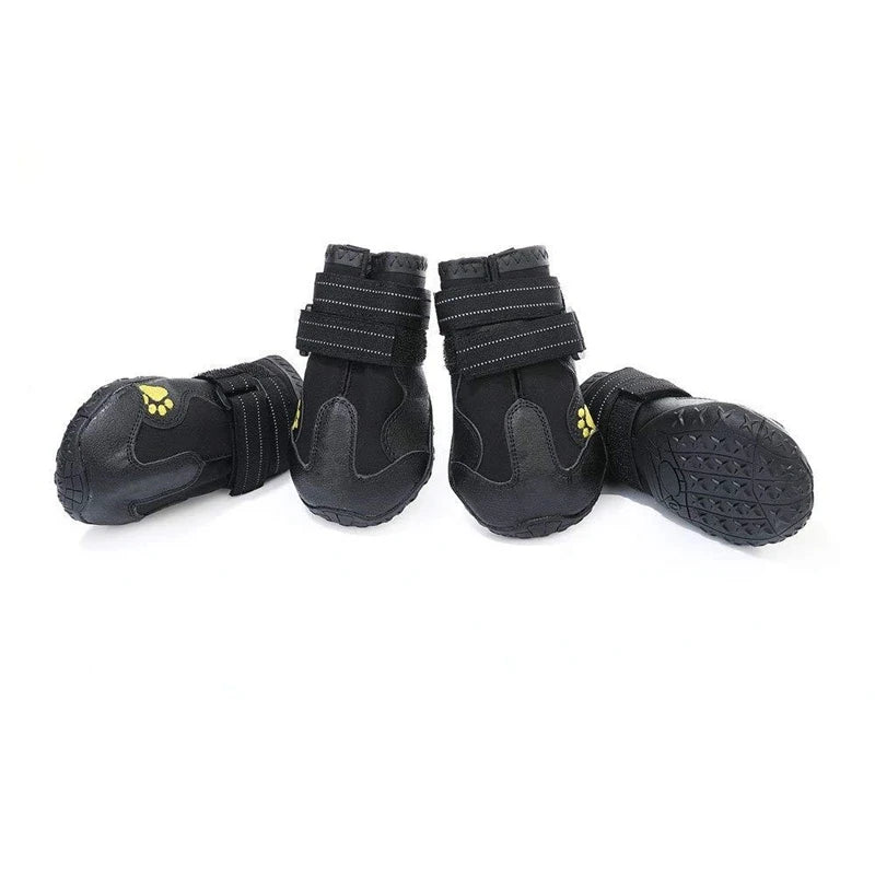 Four black dog boots with straps on a white background
