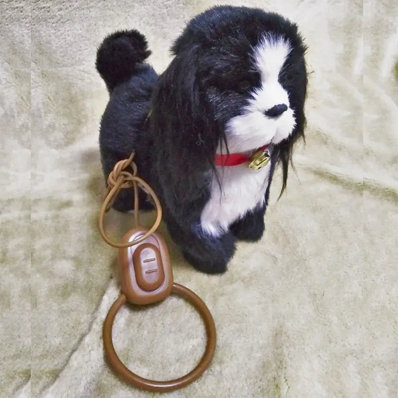 Stuffed dog toy with a remote attached to it on a beige surface