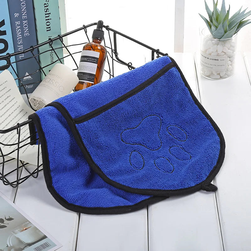 Blue pet towel with paw prints on a white surface