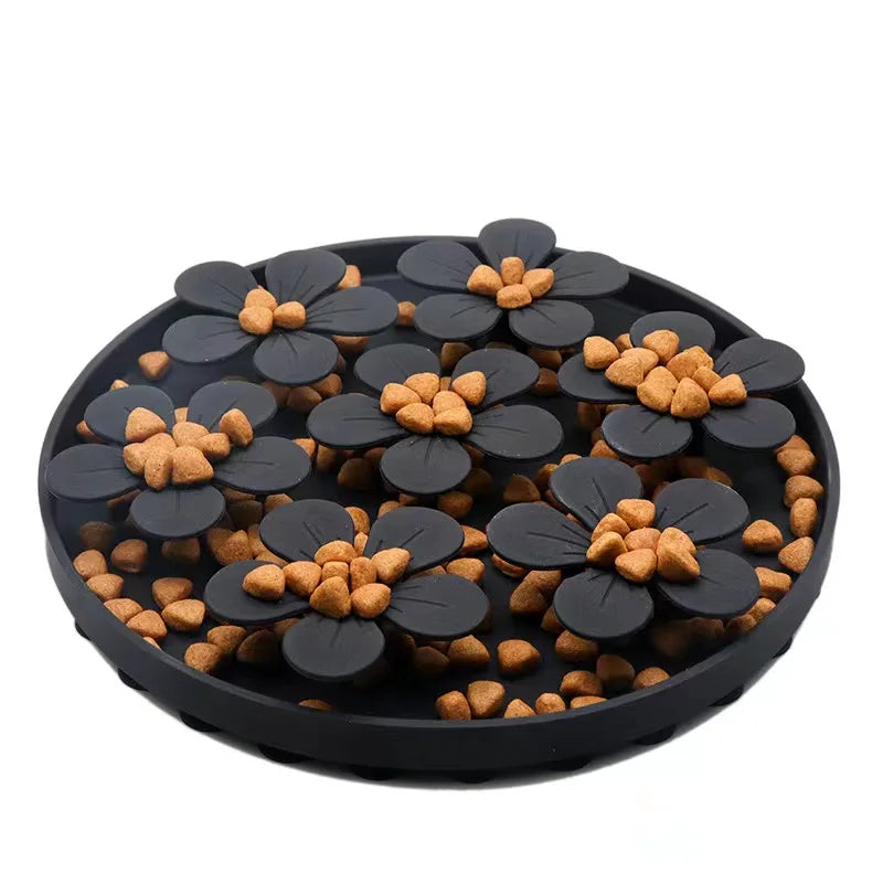 Black flower-shaped pet treat dispenser with orange treats on a white background