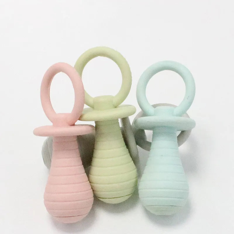 Three pastel-colored baby teething rings on a white background