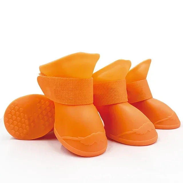 Orange dog boots with textured soles on a white background