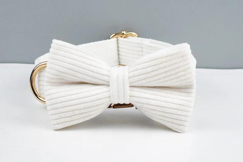 White bow-shaped clutch with gold accents on a white surface