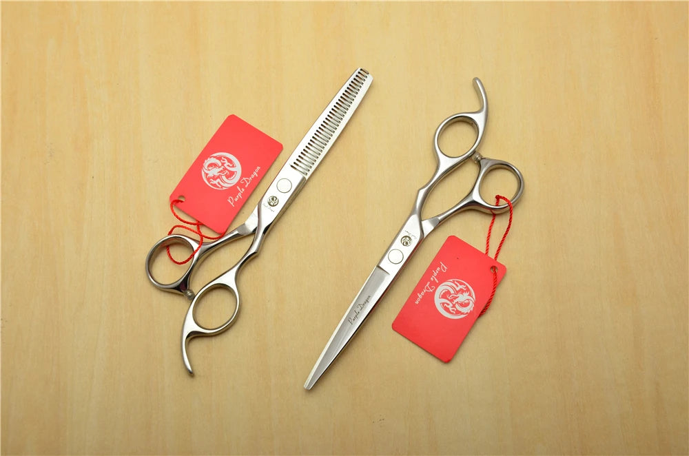 2 pairs of scissors with red tags on a wooden surface
