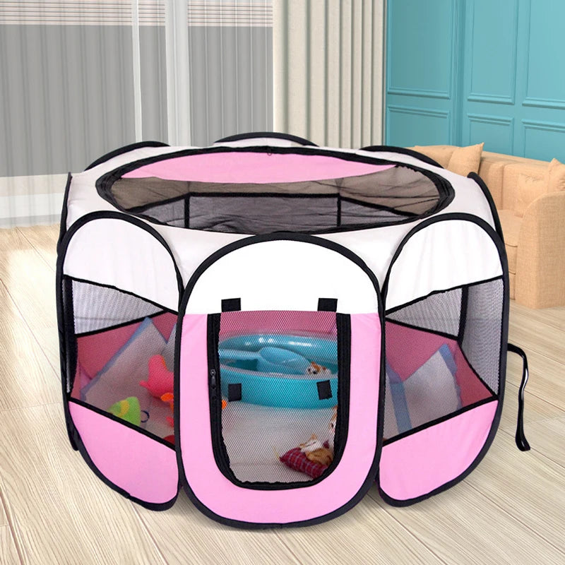Pink and white pet playpen with toys inside on a wooden floor.