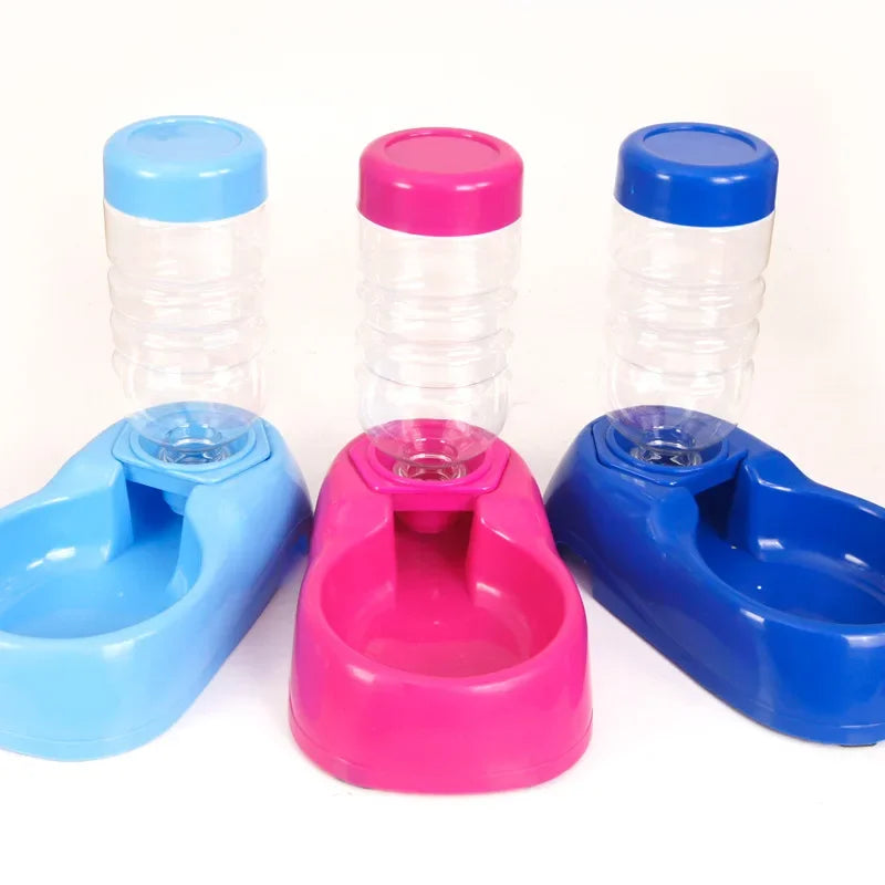 Set of three pet water bottles and feeders in blue, pink, and clear on a white background