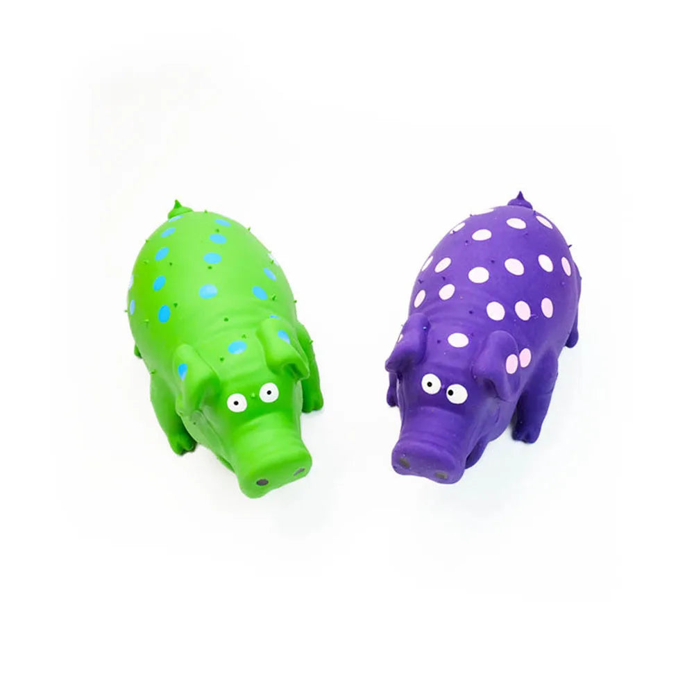 Two polka-dotted pig-shaped objects, one green and one purple, on a white background.