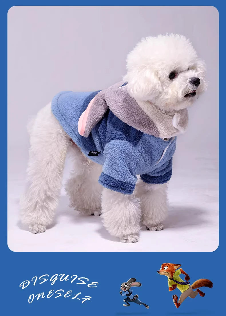 White dog wearing a blue and gray costume with cartoon characters at the bottom.