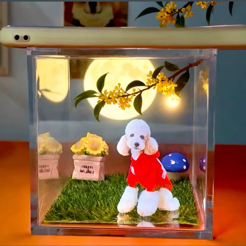 Clear decorative box with a poodle figurine in a red dress, grass, flowers, and a moonlit sky background.
