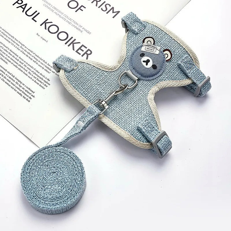 Blue pet harness and leash set with a bear design on a white surface