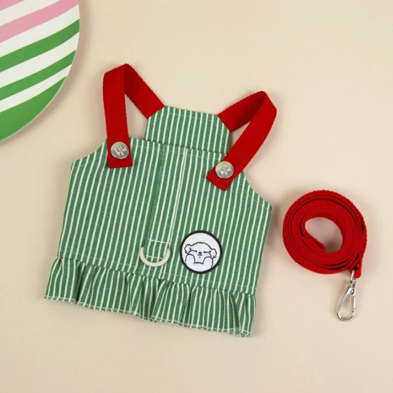 Green and white striped apron with red straps and a matching red leash on a beige background