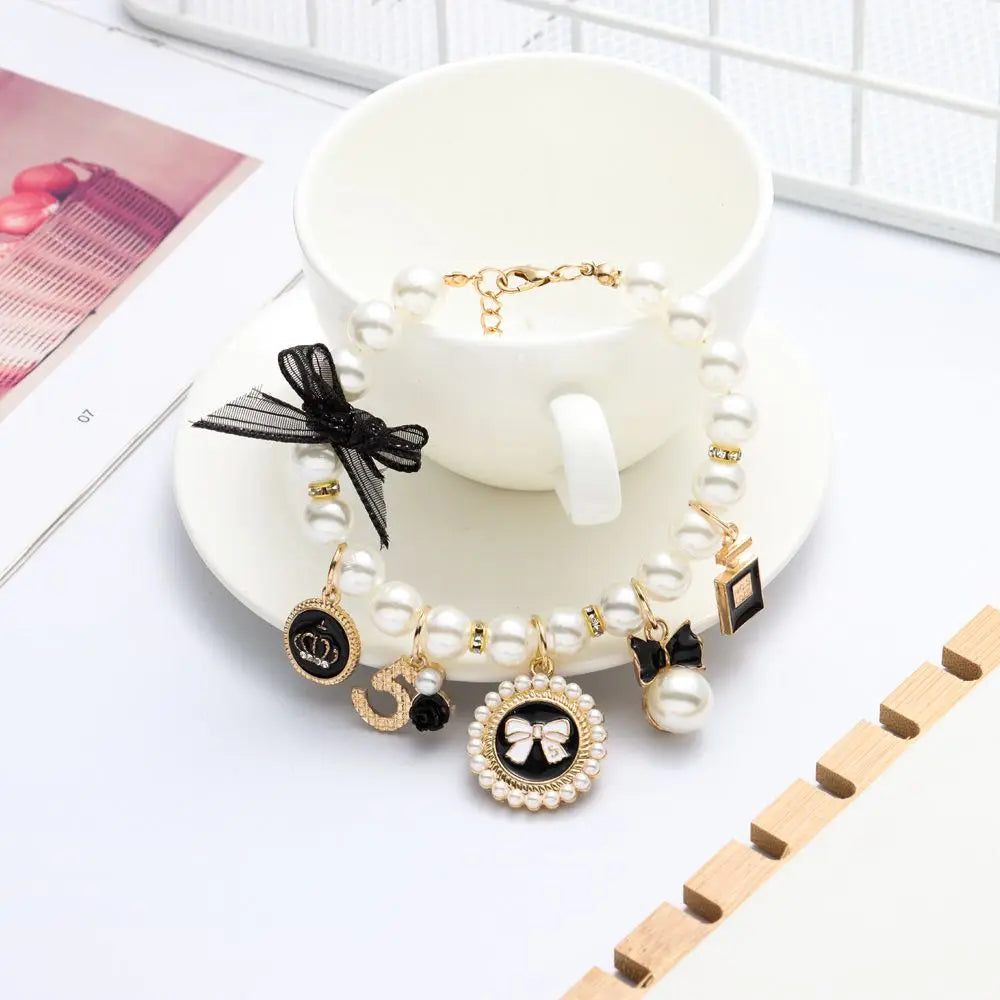 Bracelet with decorative charms on a white saucer with a cup