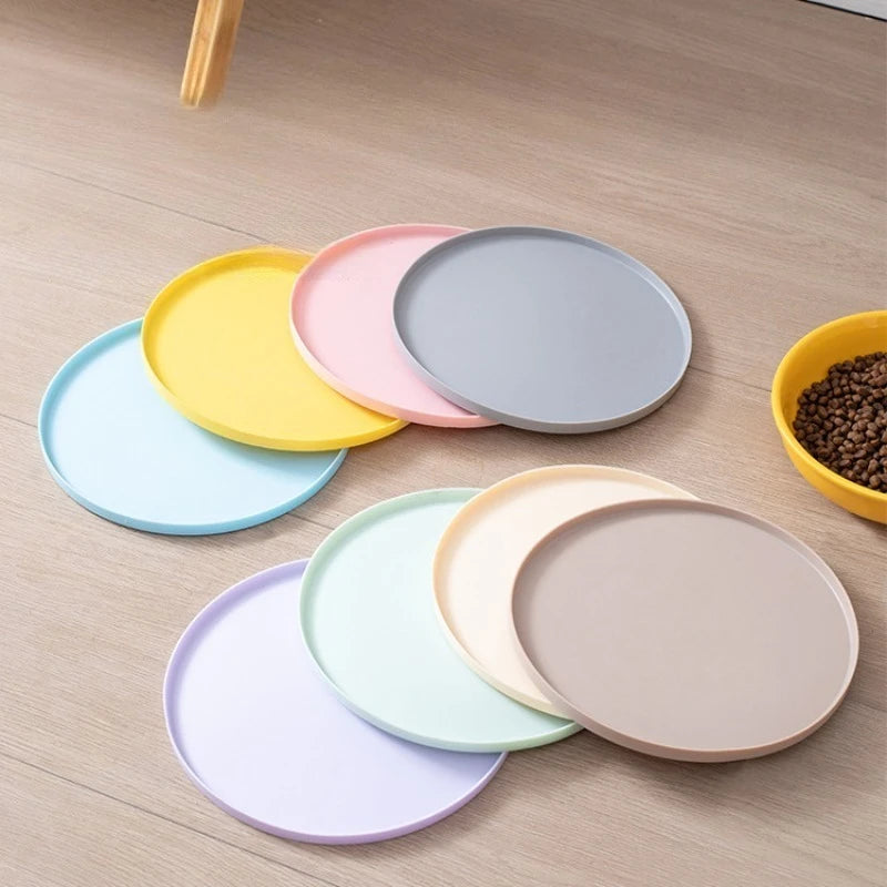 Set of colorful ceramic plates on a wooden surface with a bowl of dog food.
