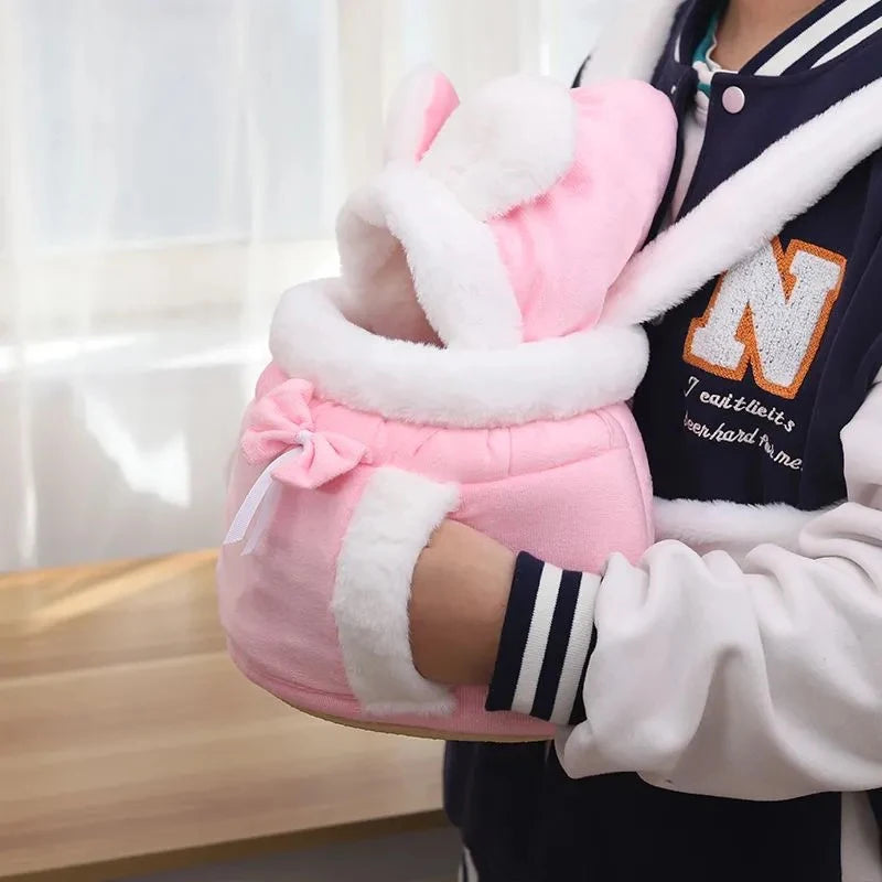 Person holding a pink plush toy with white accents