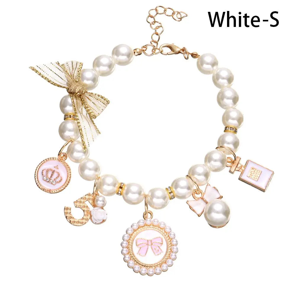 Pearl bracelet with various charms on a white background