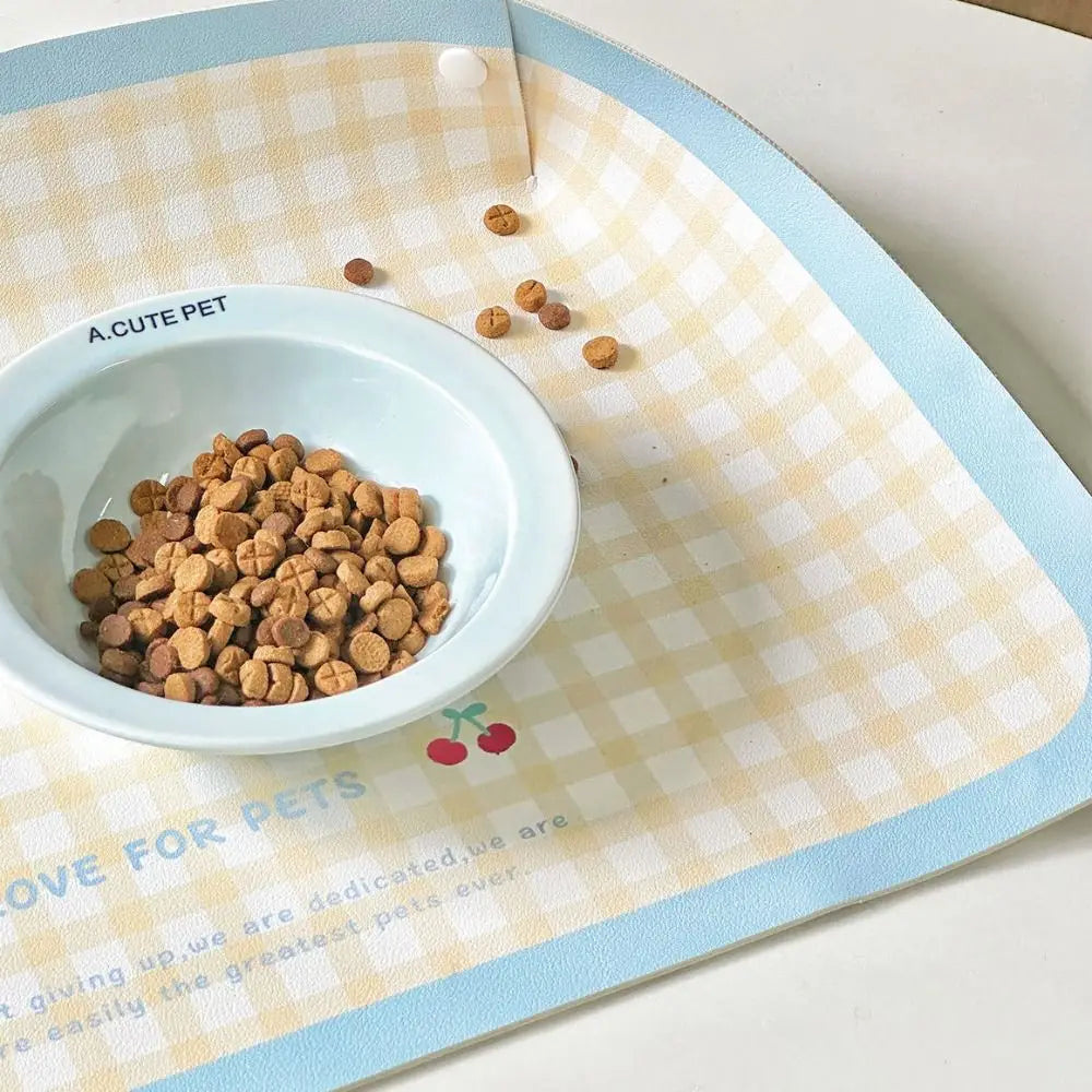 Pet bowl with kibble on a checkered mat with 'A.Cute Pet' branding.