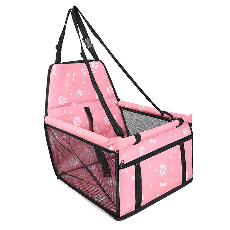 Pink pet car seat with black straps on a white background