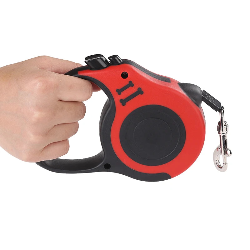 Red and black retractable dog leash held by a hand on a white background