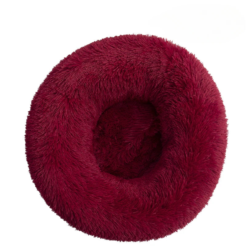 Red fluffy donut-shaped pet bed on a white background