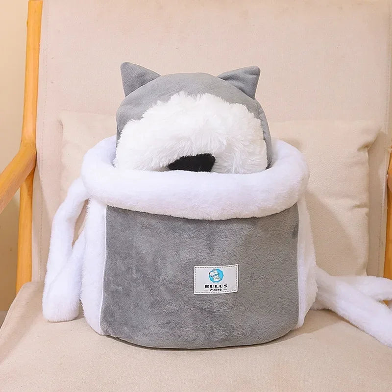 Gray plush cat-shaped cushion with white accents on a beige chair.