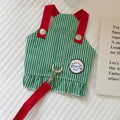 Green and red striped apron with a patch on a textured surface