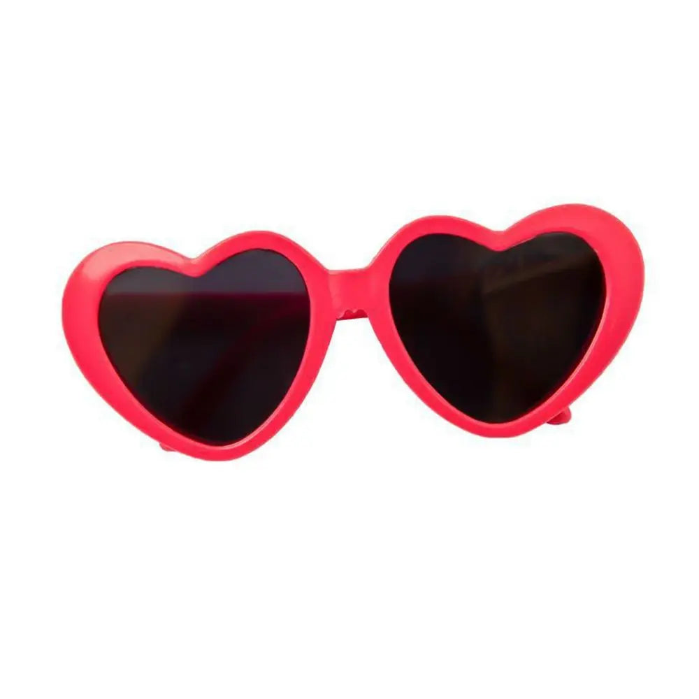 Heart-shaped sunglasses with red frame and dark lenses on a white background