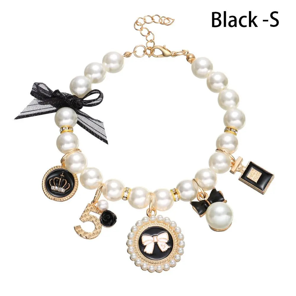 gold and pearl necklace with black bow and  6 gold and black charms 
