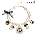 gold and pearl necklace with black bow and  6 gold and black charms 